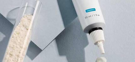 A tube of SkinCeuticals Retinol 0.3 night cream, with a small amount of cream squeezed out, is displayed beside a transparent vial of white powder on a light blue background.