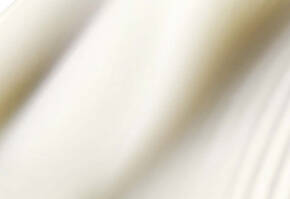 Tissu blanc drape, creant des ondulations douces et elegantes, evoquant legerete et fluidite.