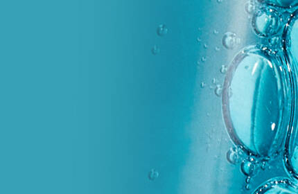Close-up of a blue liquid with bubbles, set against a light background.