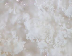 Close-up of fluffy, white crystalline texture resembling snow or a soft cloud.
