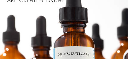 A close-up of a brown glass dropper bottle of SkinCeuticals C E Ferulic vitamin C serum, surrounded by similar bottles, with a text overlay that reads "Not all Vitamin C serums are created equal."
