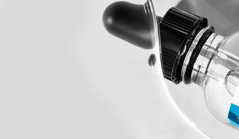 Close-up of a white medical device with a black dial and a transparent section, set against a light gray background.