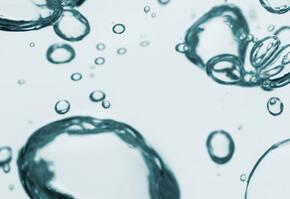 Bubbles d'eau flottant dans un liquide clair, creant un effet de texture apaisant et dynamique.