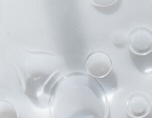 Bulles d'air flottant a la surface d'un liquide clair, creant une texture visuelle delicate.