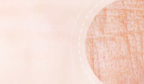 Abstract image featuring a soft, peach-colored background with a circular pattern that resembles textured skin.