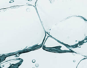 Close-up of ice cubes submerged in clear water, with bubbles rising and creating a refreshing, cool atmosphere.