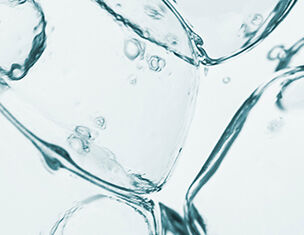 Close-up of clear ice cubes with air bubbles suspended in water, creating a refreshing, cool visual effect.