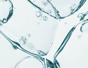 Close-up of clear ice cubes with air bubbles suspended in water, creating a refreshing, cool visual effect.