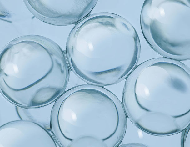 Transparante, glanzende luchtbellen op een zachte blauwe achtergrond.