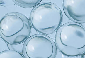 Glanzende, transparante bellen op een lichtblauwe achtergrond, met subtiele reflecties en schaduwen.