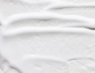 Close-up of smooth, white cream with soft, flowing texture and subtle ridges.