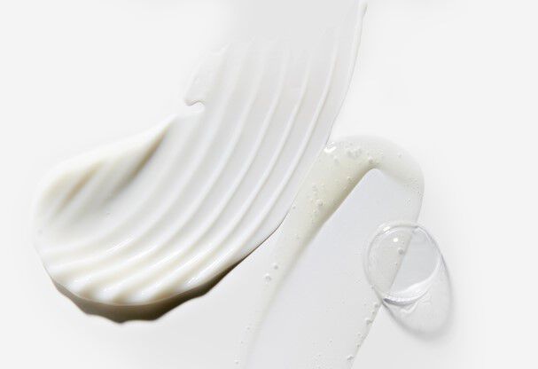 Alt-tekst: Drie verschillende texturen van witte cremes op een lichte achtergrond.