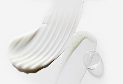 Alt-tekst: Drie verschillende texturen van witte cremes op een lichte achtergrond.