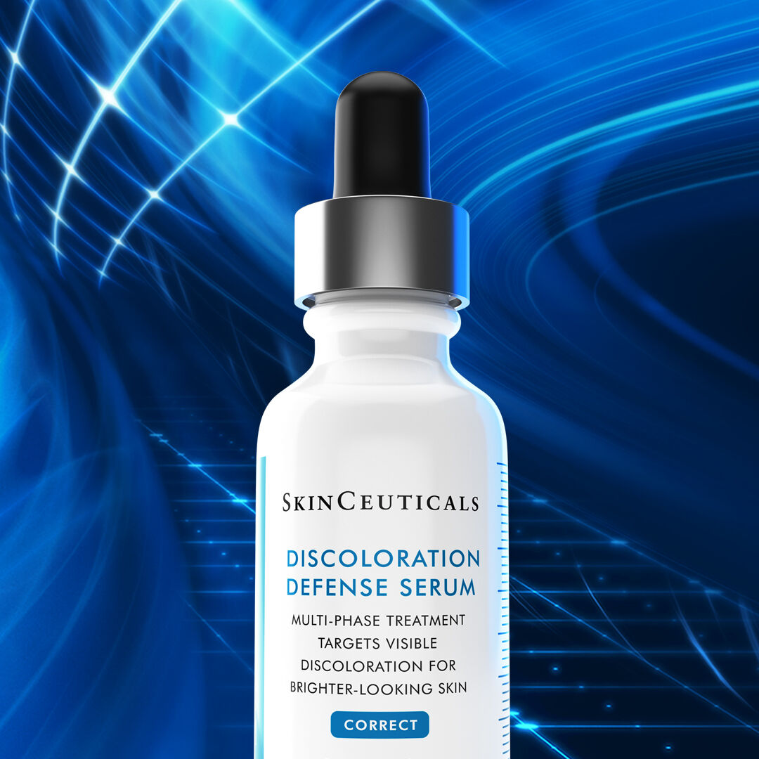 A white serum bottle with a dropper cap, labeled "SkinCeuticals Discoloration Defense Serum," against a vibrant blue abstract background. The text highlights that it targets visible discoloration for brighter-looking skin.