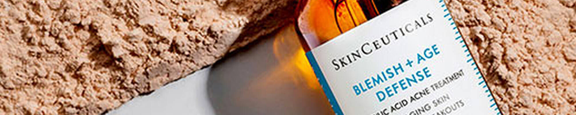 Flacon SkinCeuticals Blemish + Age Defense serum sur une texture claire.