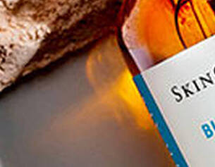 Flacon SkinCeuticals Blemish + Age Defense serum sur une texture claire.