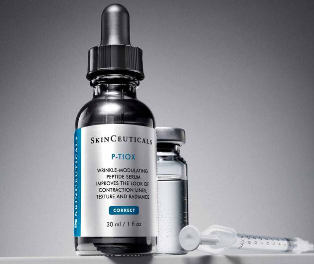 Flacon de serum anti-rides SkinCeuticals P-TIOX, a cote d'une petite ampoule et d'une seringue, sur fond gris.