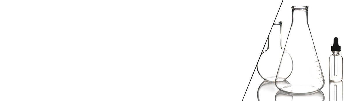 Three glass laboratory flasks and a dropper bottle on a reflective surface, set against a plain white background.